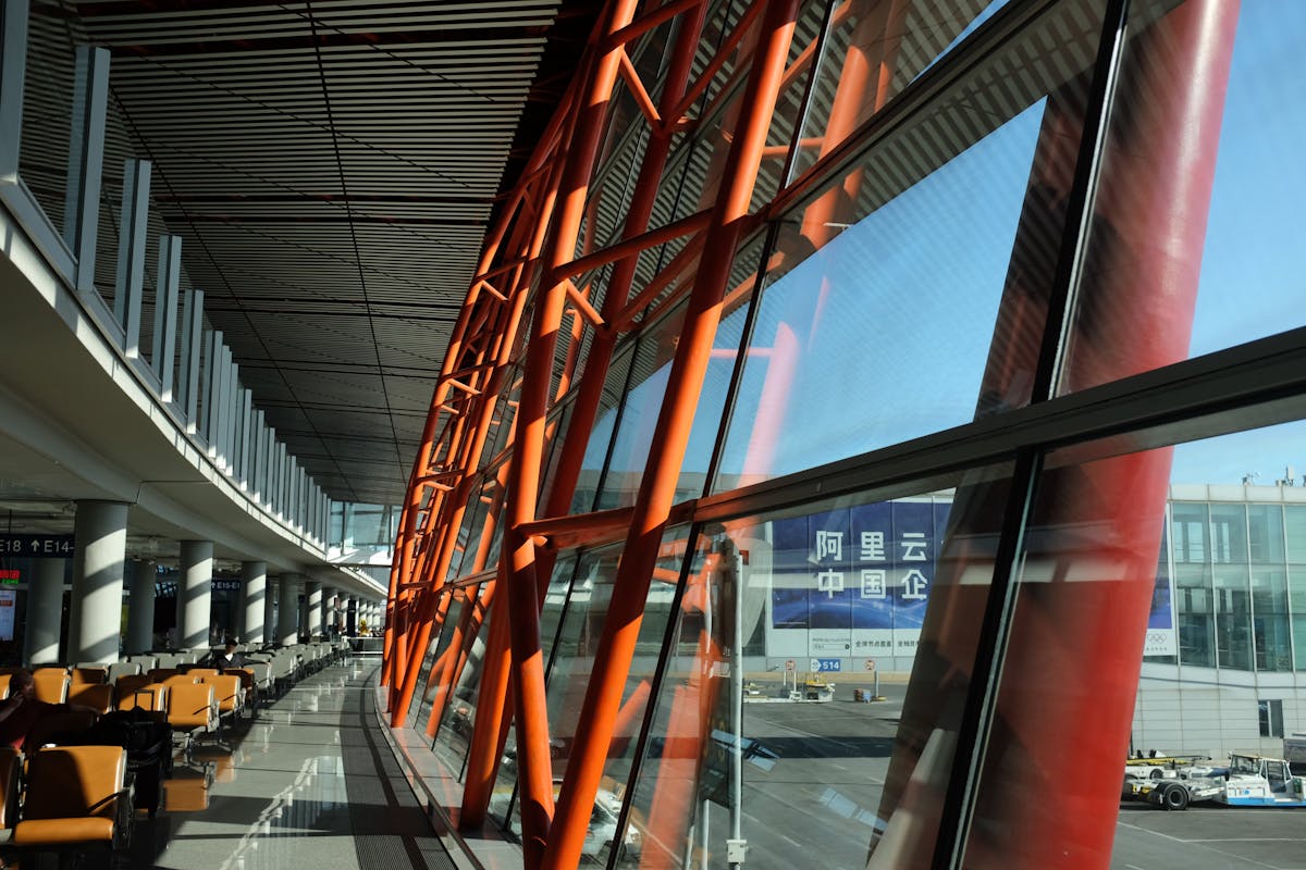 Modern airport terminal with distinctive orange steel architecture and glass windows