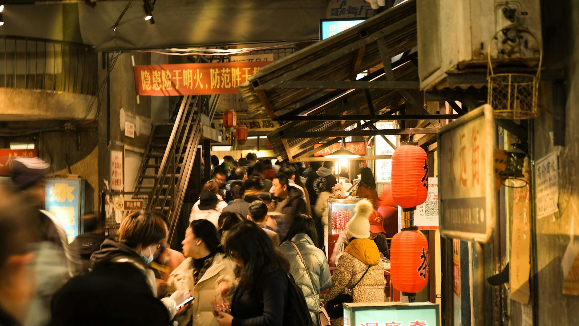 Crowded evening street market in China lit up at night