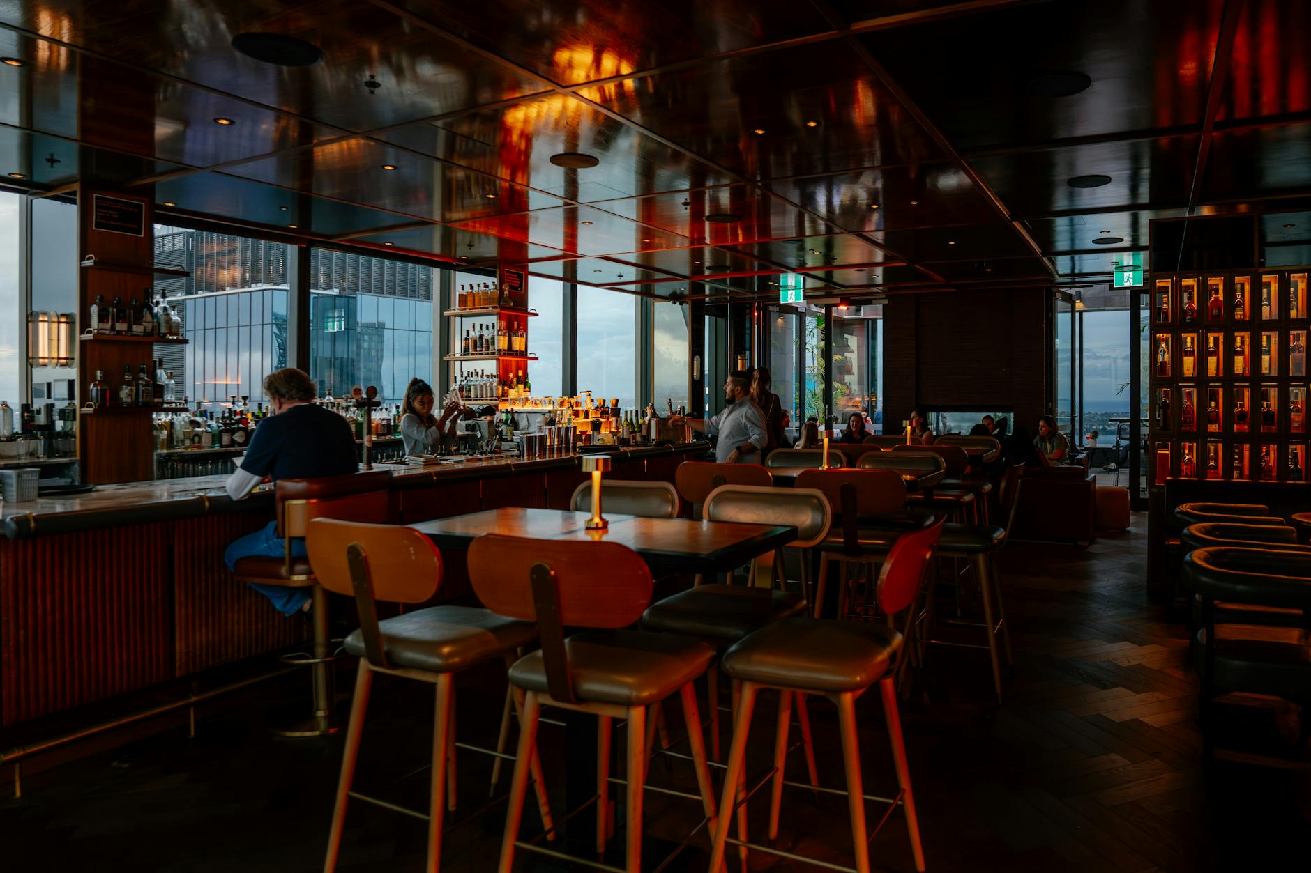 Warm, dimly lit rooftop bar with patrons at night