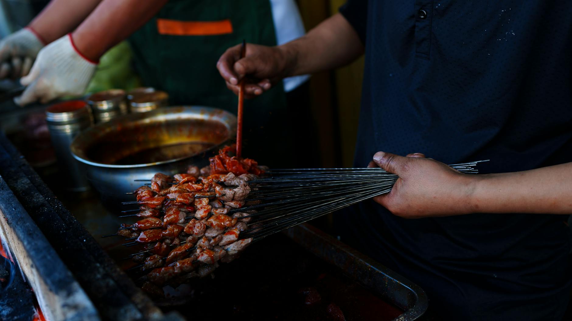 Street vendor grilling skewers at a food stall