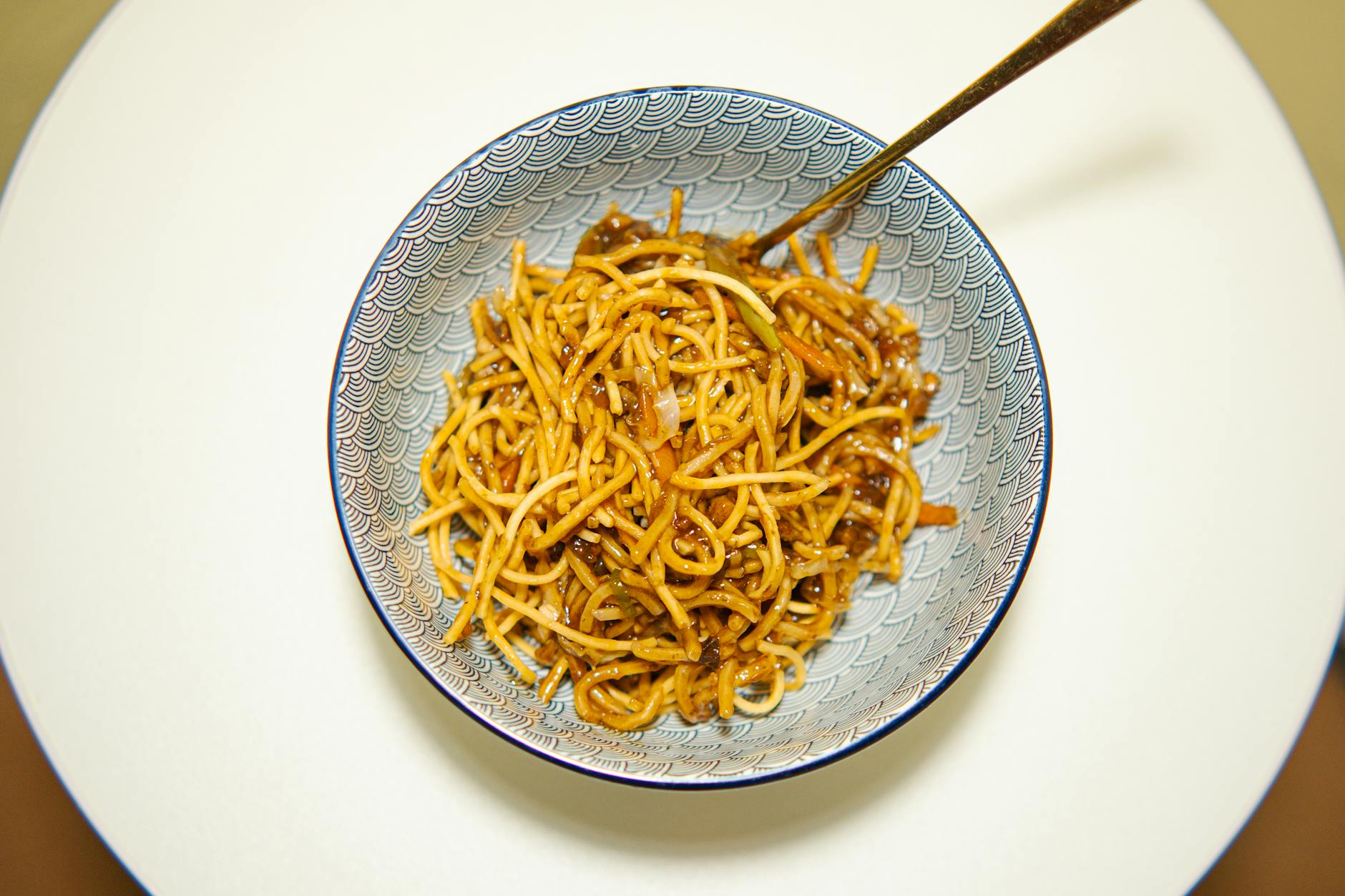 Bowl of Chinese noodles with toppings and chopsticks