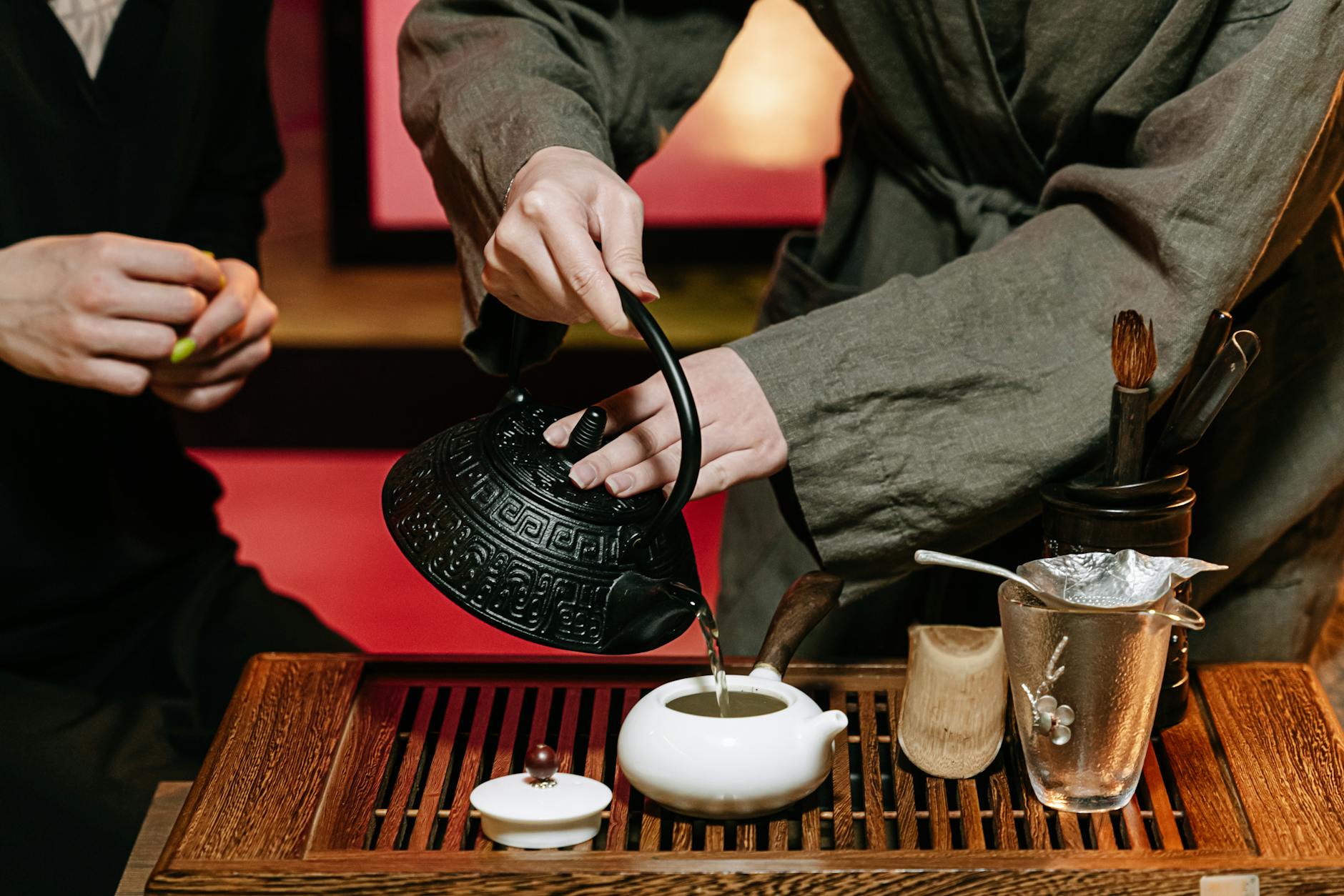 Hands pouring tea during a traditional Chinese ceremony