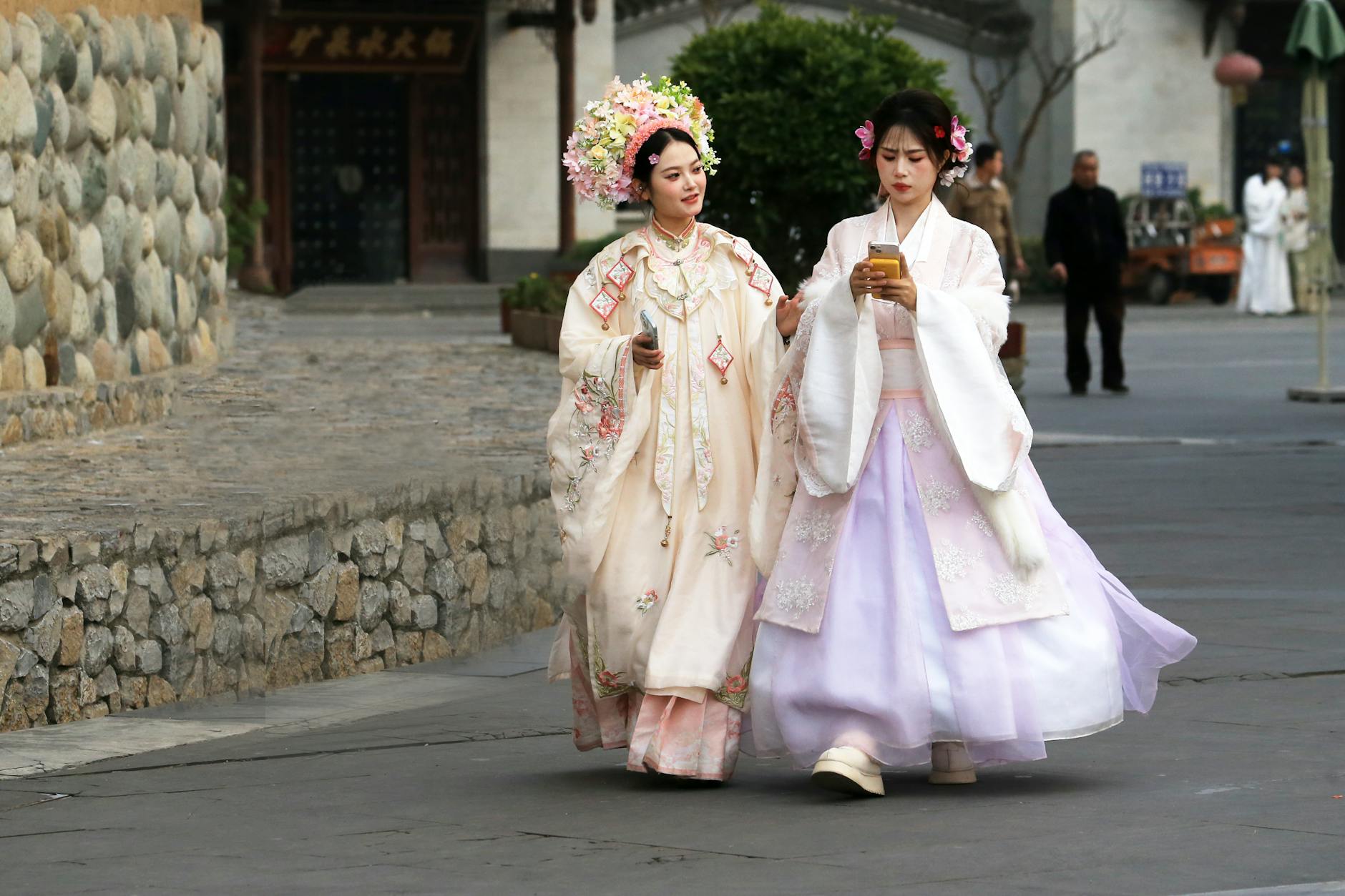 Two women in traditional Hanfu strolling outdoors