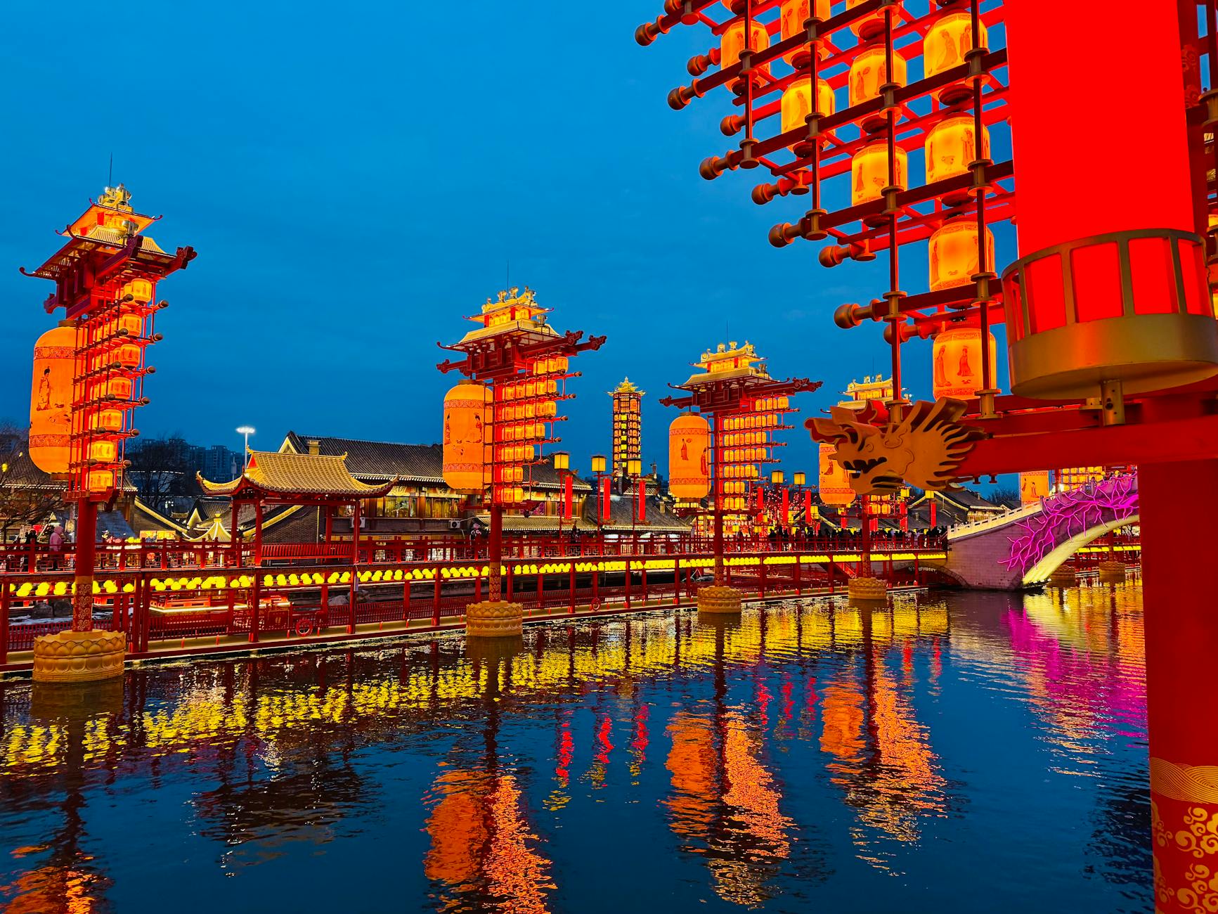 Evening view of a traditional Chinese lakeside lit with lanterns