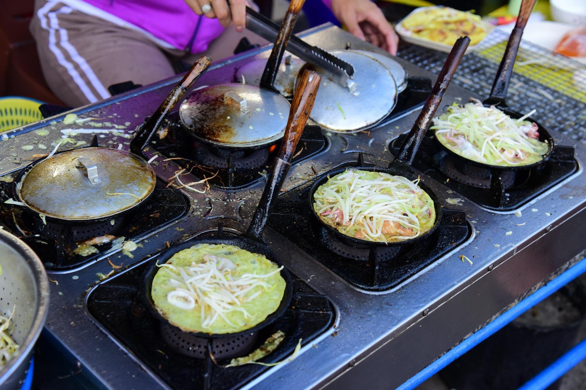Vendor cooking a savory Chinese pancake on a griddle