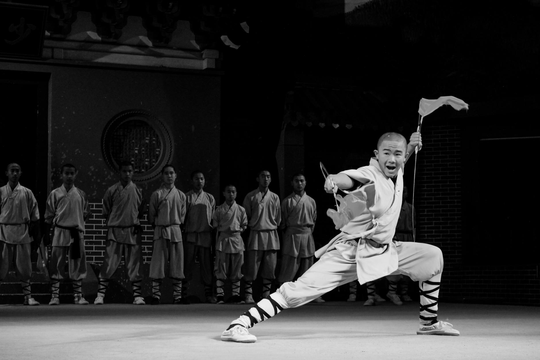 Martial artist performing an energetic kung fu pose on stage