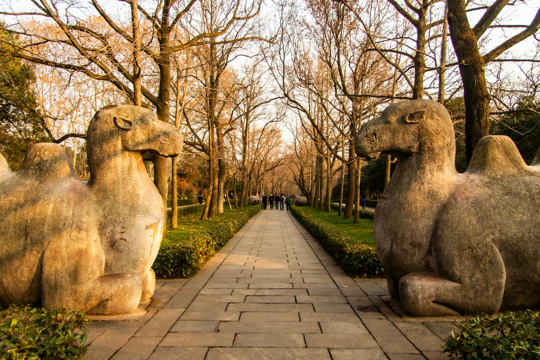 Ancient stone camel statues lining a ceremonial pathway