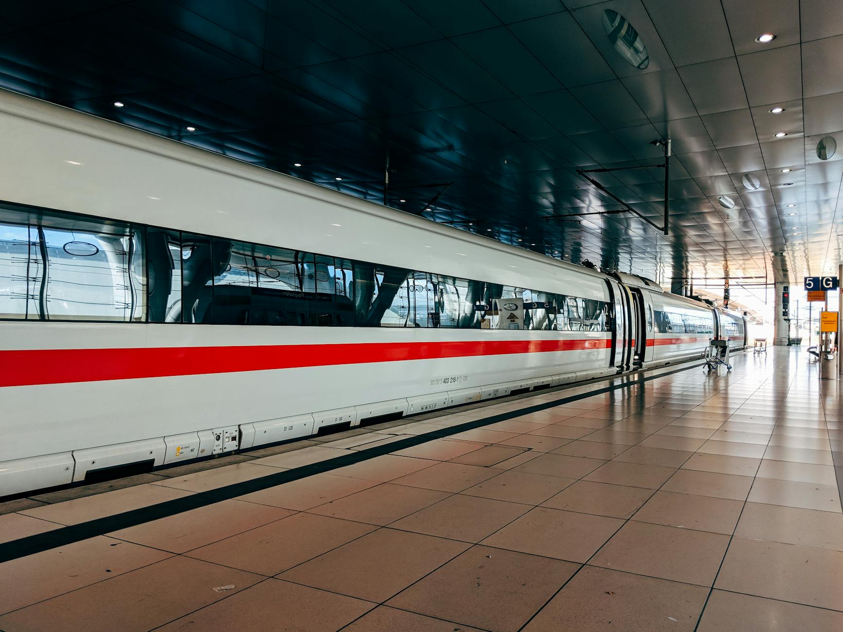 Sleek white Beijing high-speed train arriving at a modern Chinese station platform