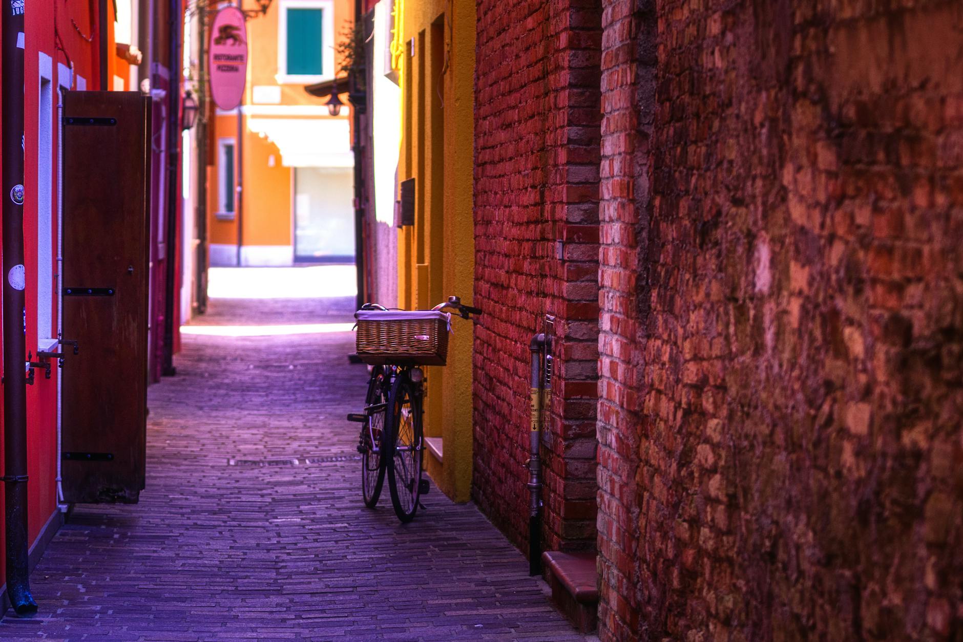 Tourist on a colorful shared bike riding through a traditional Beijing hutong with grey walls