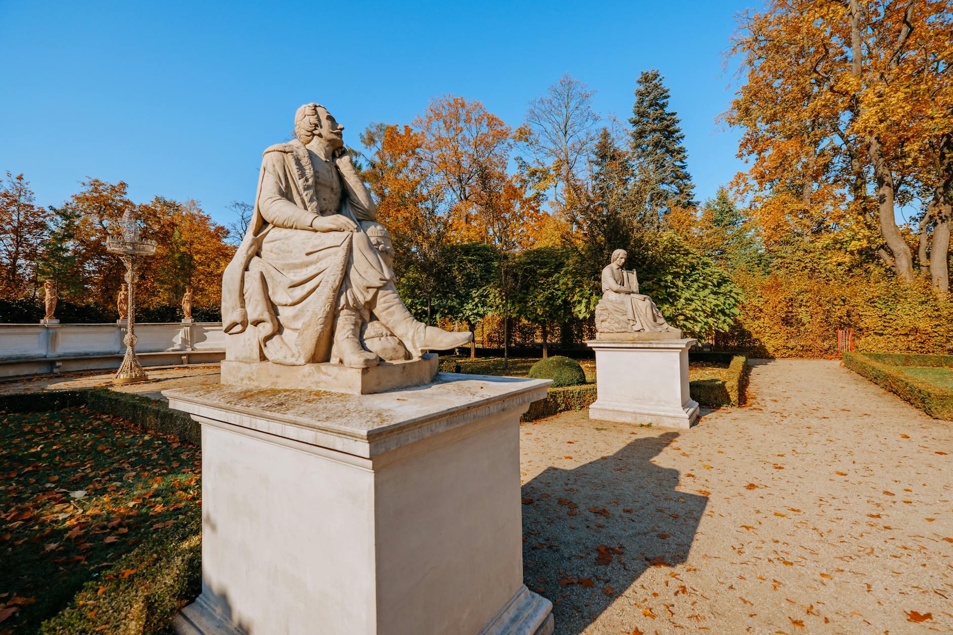 Stone statues surrounded by vibrant autumn foliage