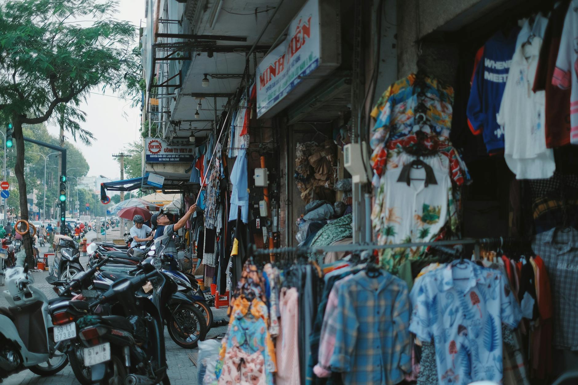 Clothing stalls packed with garments at a busy market