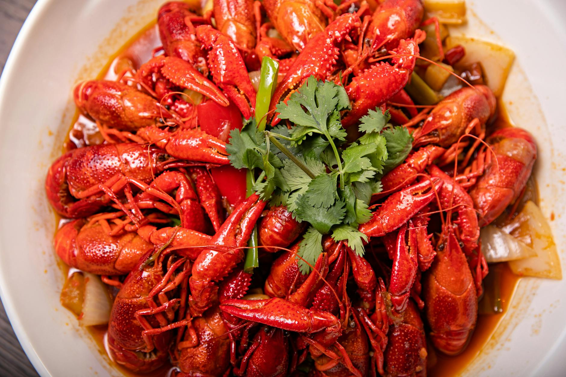 Plate of spicy crayfish garnished with chilli and cilantro