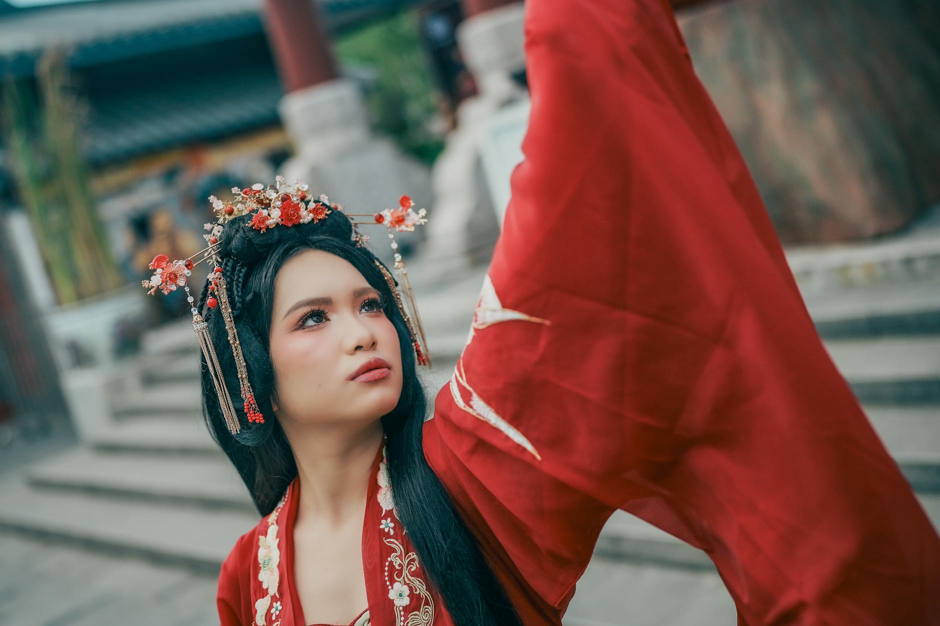 A woman in a red Hanfu dress posing outdoors