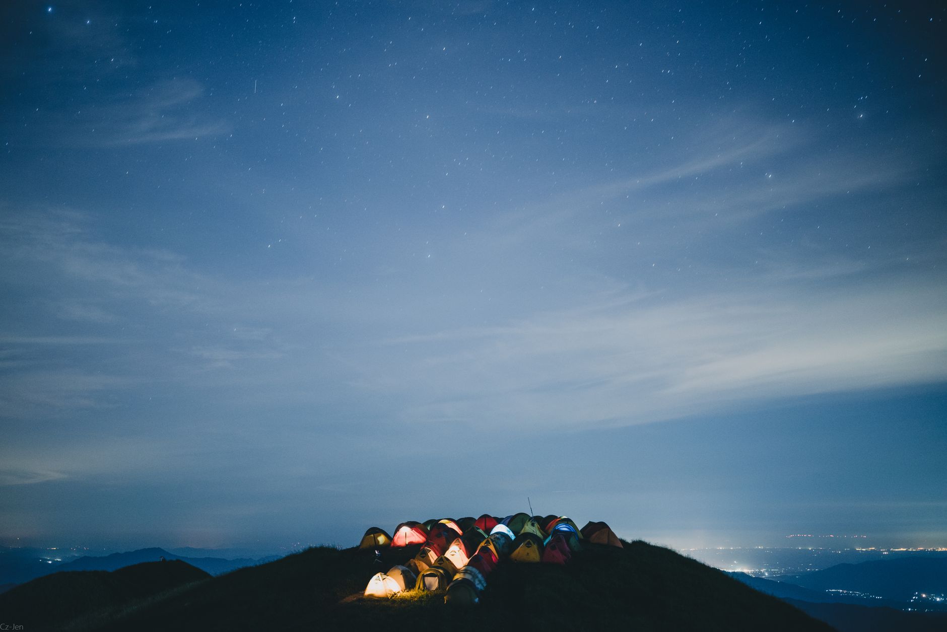 Camping under stars near Great Wall of China mountains at night