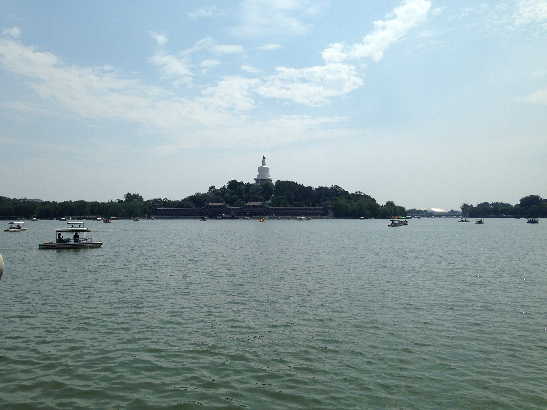 Pedal boats on the lake at Beihai Park with the White Dagoba on its wooded island behind