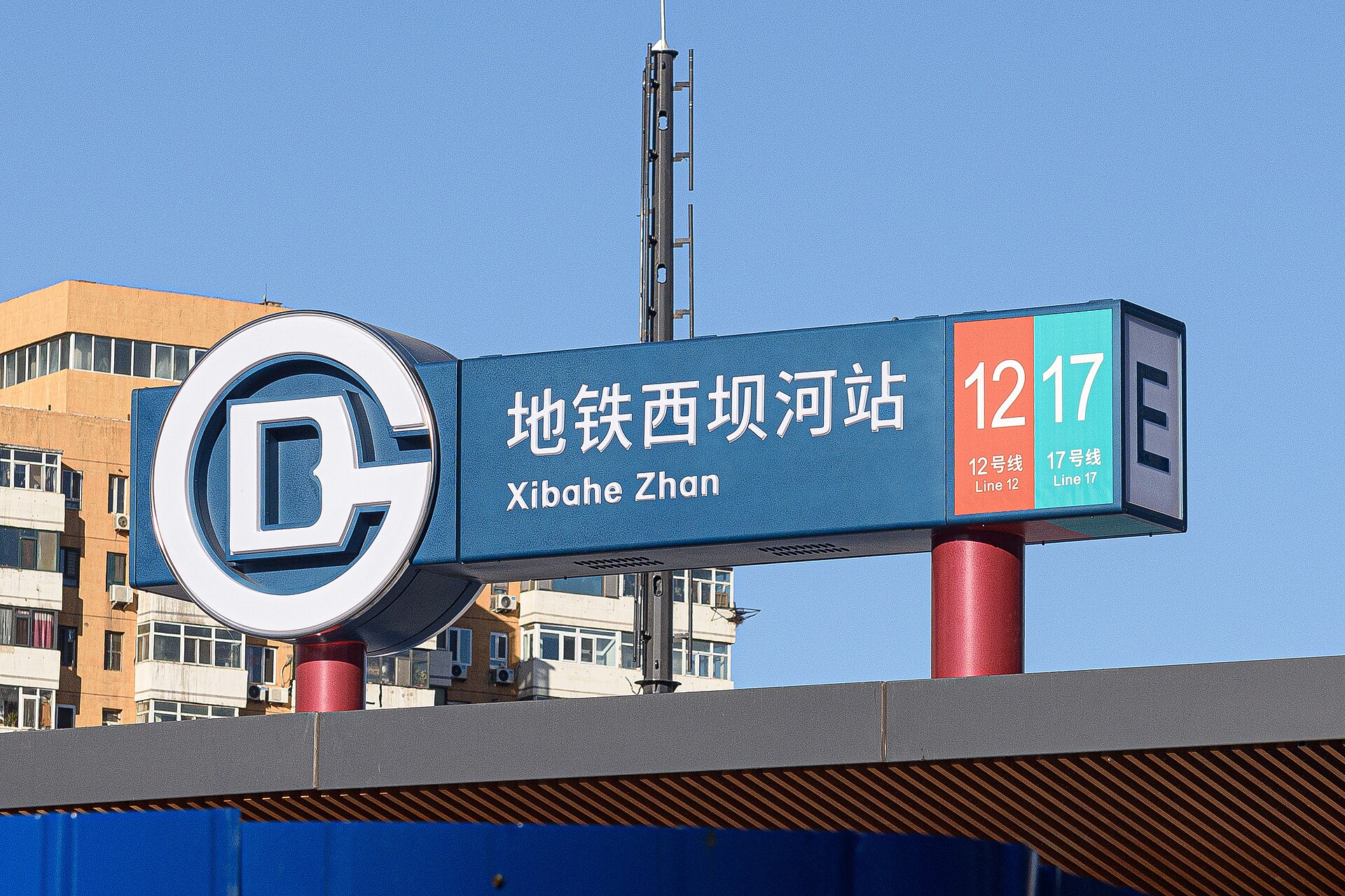 A Beijing Subway station sign for Xibahe Station showing the subway logo, the station name in Chinese and pinyin, Lines 12 and 17, and the exit letter E