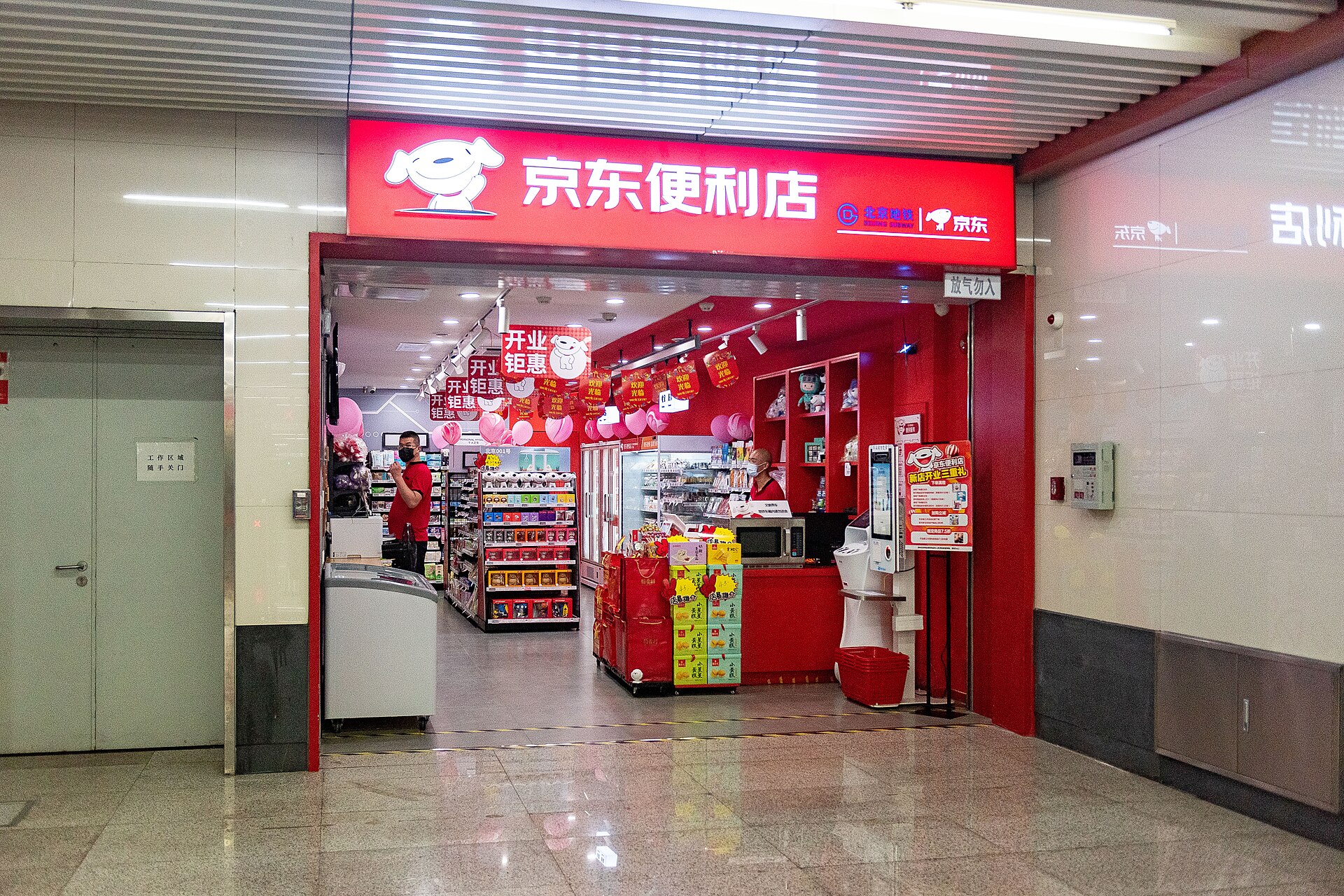 A JD convenience store with a red shopfront inside the concourse of Caishikou station on Beijing subway Line 7