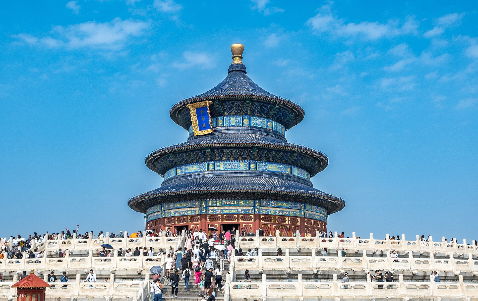 The blue-tiled circular Hall of Prayer for Good Harvests at the Temple of Heaven with visitors on the white marble terraces below