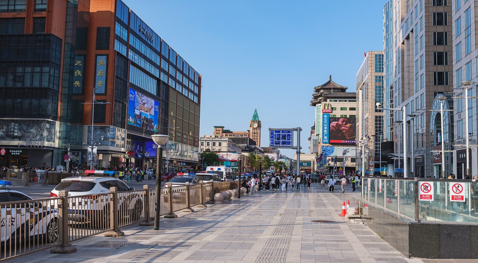 The pedestrianised Wangfujing shopping street in Beijing with department stores and the old clock tower behind