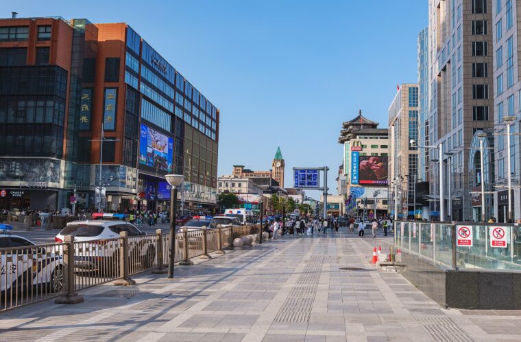 The pedestrianised Wangfujing shopping street in Beijing with department stores and the old clock tower behind
