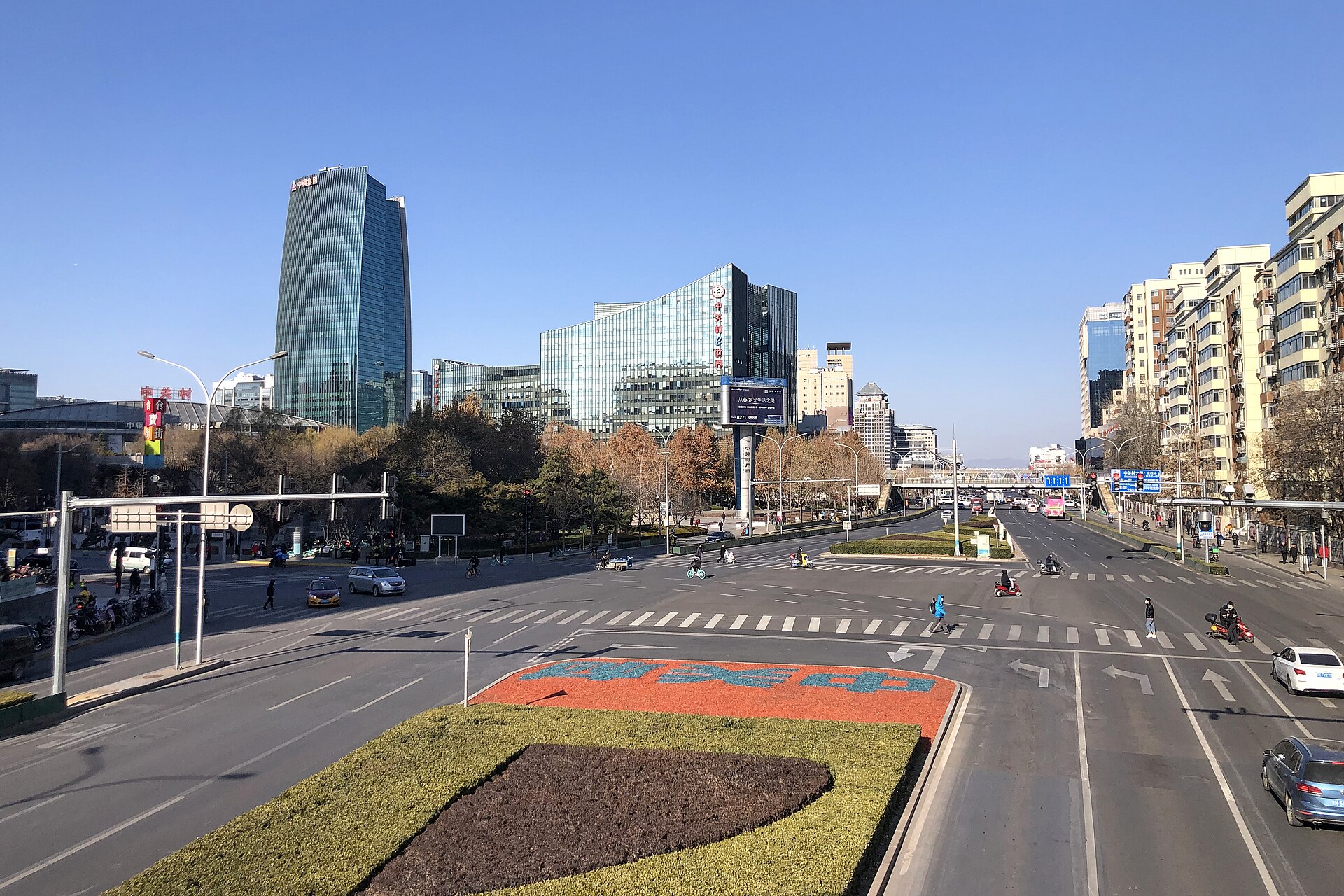 A wide road junction in the Zhongguancun district of Beijing with glass office towers under a clear winter sky