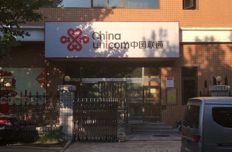 A China Unicom storefront on Beiyuan Road in Beijing displays its red logo and bilingual sign above the entrance steps.