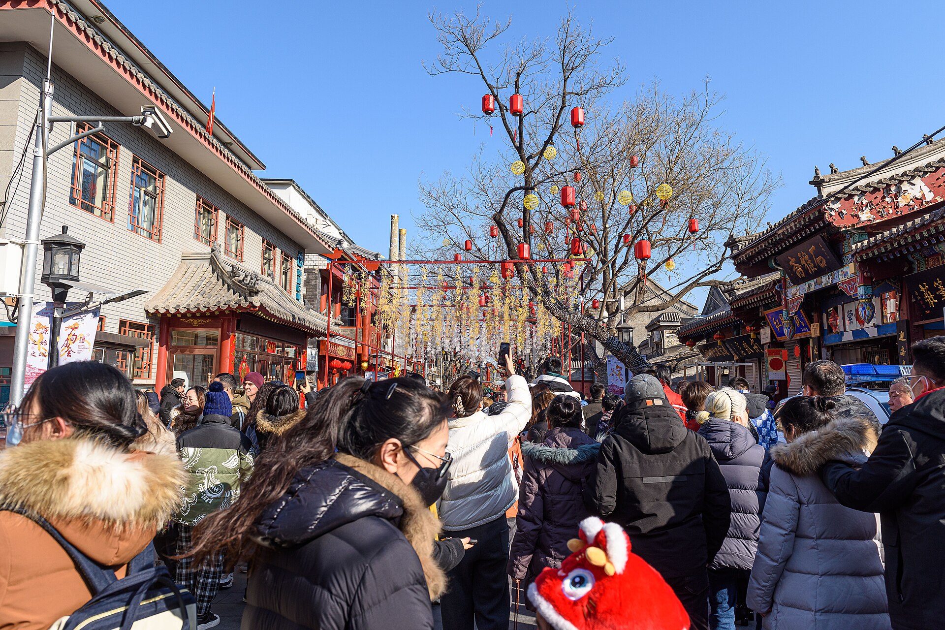 Crowds walk along Liulichang West Street in Beijing under strings of red lanterns during the Changdian Temple Fair.