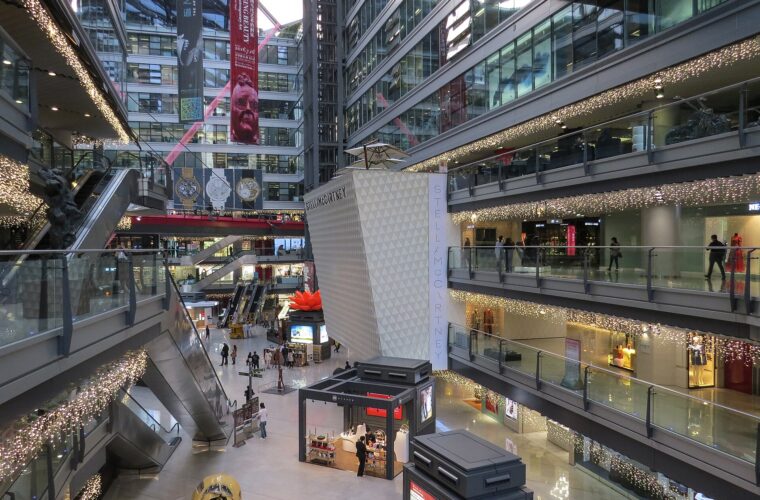 Escalators and glass walkways connect several floors of shops around the tall atrium at Parkview Green in Beijing.