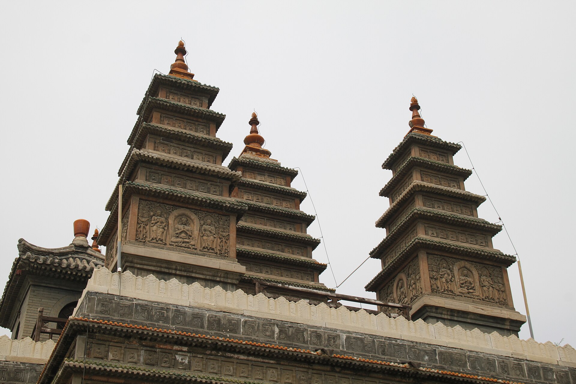 Three of the five stone pagodas on top of the Five Pagoda Temple in Beijing, carved with rows of small seated Buddhas
