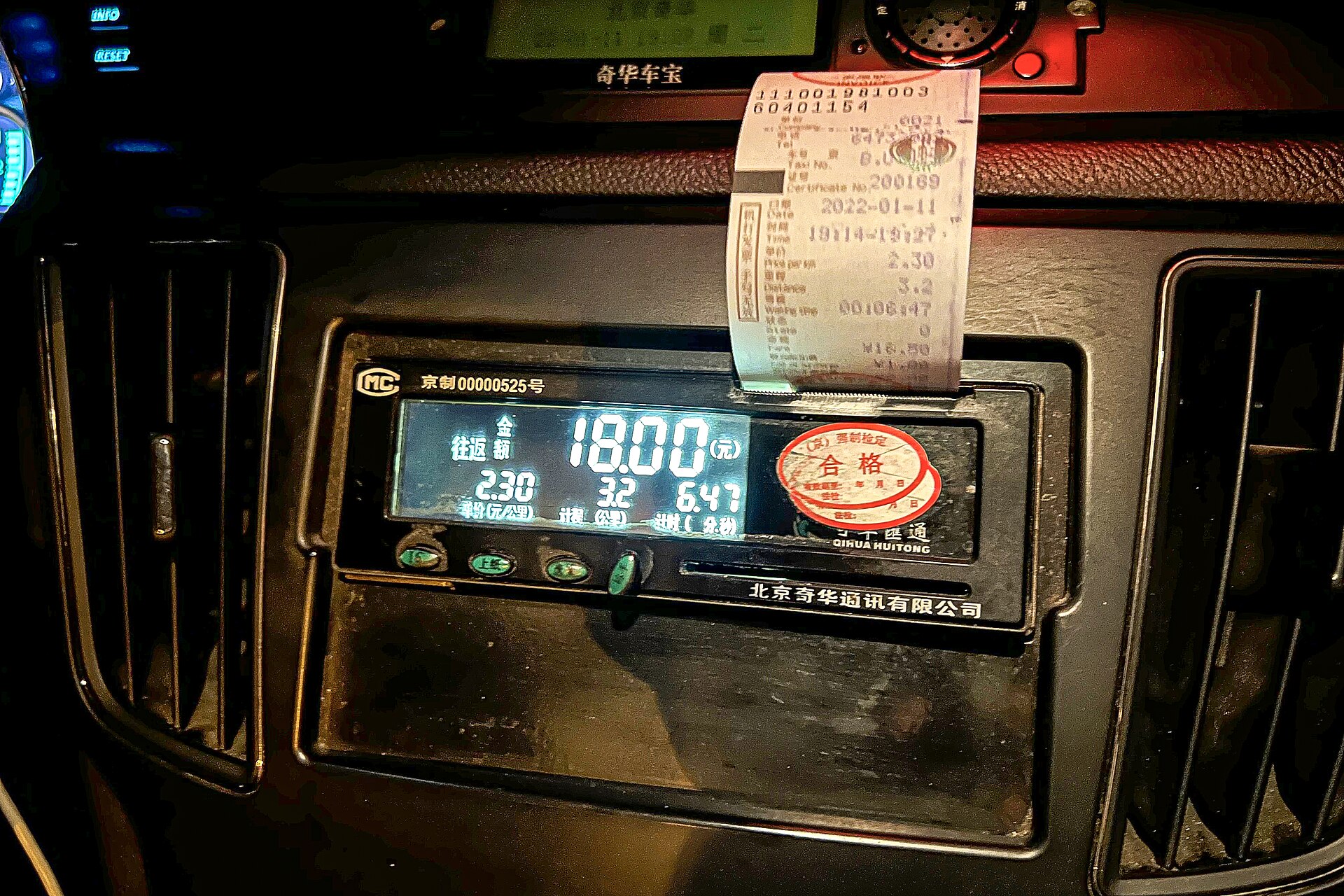 An illuminated Beijing taxi meter shows eighteen yuan while a printed journey receipt hangs above the dashboard display.
