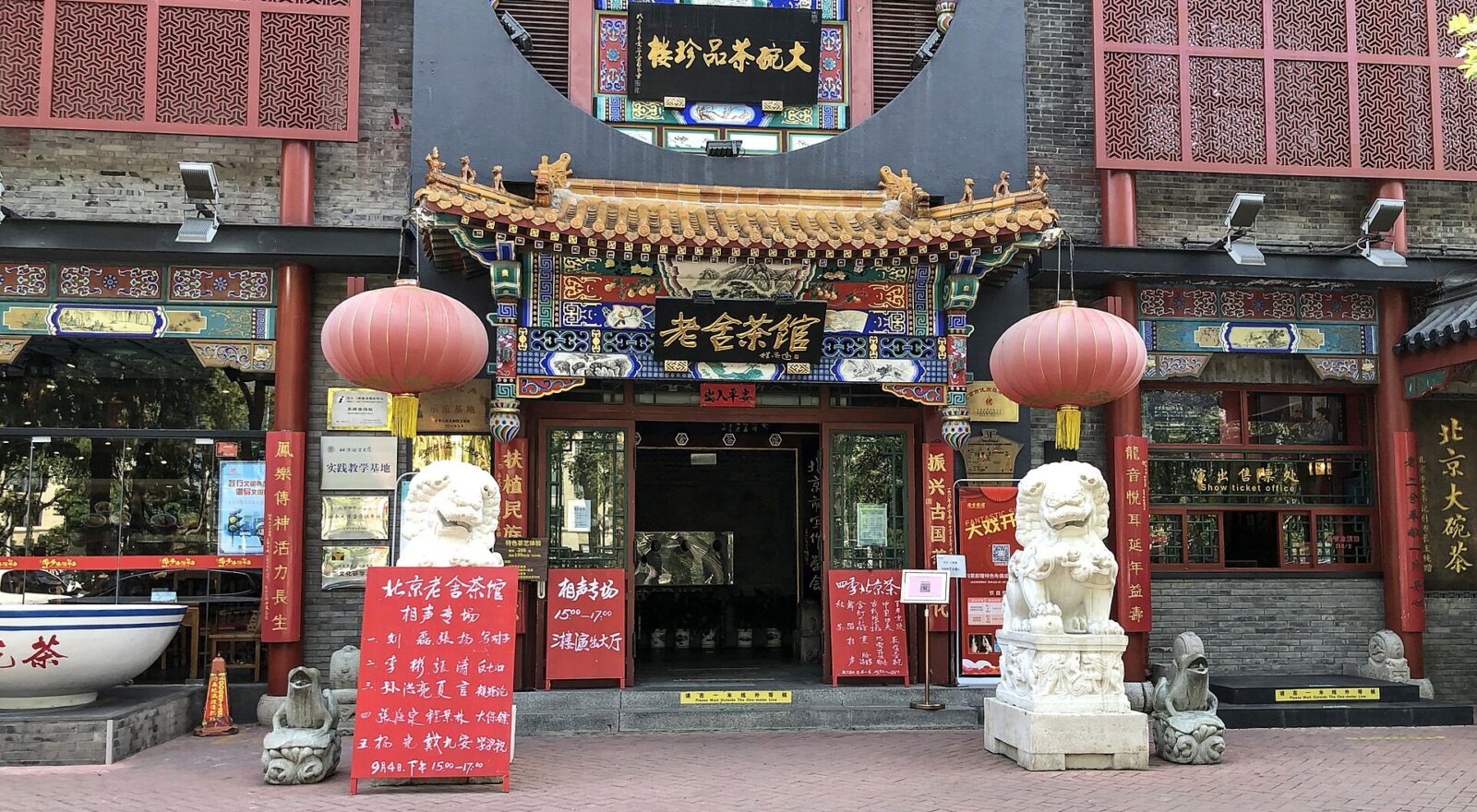 Red lanterns and stone lions flank the ornate entrance to Lao She Teahouse in Beijing.