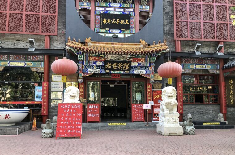 Red lanterns and stone lions flank the ornate entrance to Lao She Teahouse in Beijing.